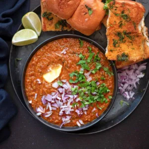 Snap Bite Bhaji served with butter-toasted pav, chopped onions, fresh coriander, butter, and lemon wedges